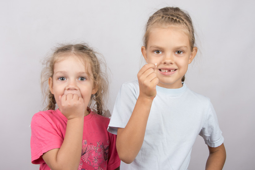 Kinder freuen sich über den Verlust des ersten Milchzahns